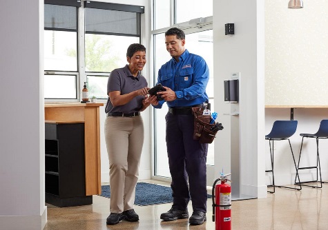 Cintas employee reviewing fire extinguisher inspection