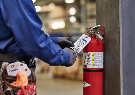 Cintas employee doing a fire extinguisher inspection