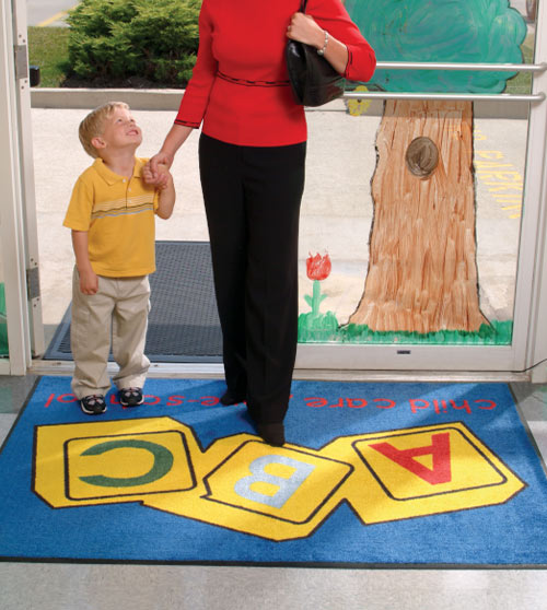 A Cintas Custom Logo Floor Mat adorns the entrance of a child care facility.