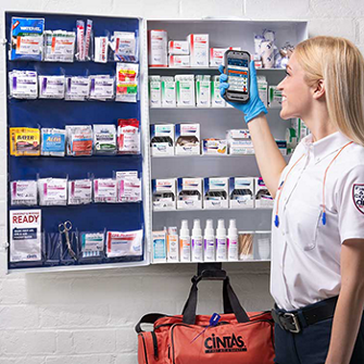 Cintas employee checking the stock of first aid cabinet supplies